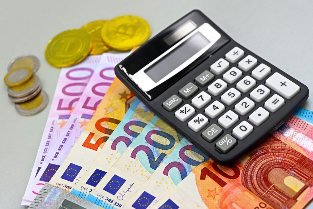 Billetes de euro y calculadora para calcular la amortización de una aerotermia