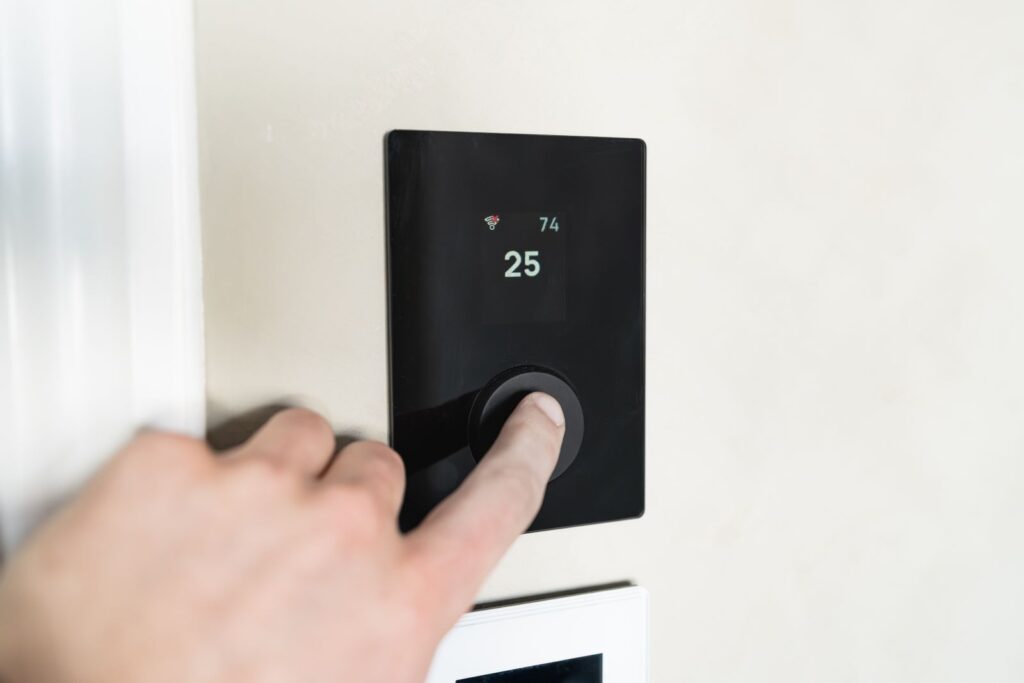 Termostato digital de aerotermia en la pared de una vivienda